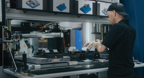 Le robot Leonardo d’EROWA est chargé en pièces par une personne.