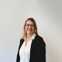 Porträt von Karin Flashar vor neutralem Hintergrund.